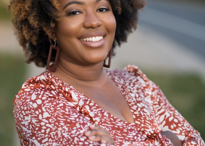 Black middle aged woman smiling in animal print dress
